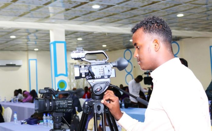 A journalist looks into his camera during the General Congress of Somali Journalists Syndicate (SJS) in Mogadishu on June 22, 2019. | Photo credit SJS.