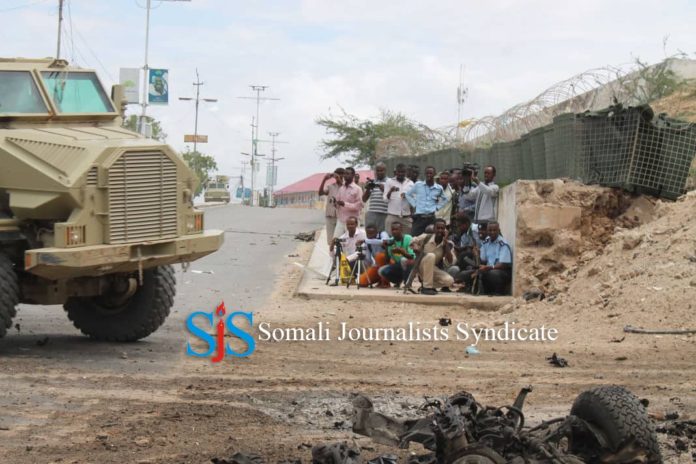 Journalists take shelter for safety as they were covering blast site in Mogadishu. | Photo Credit/SJS.