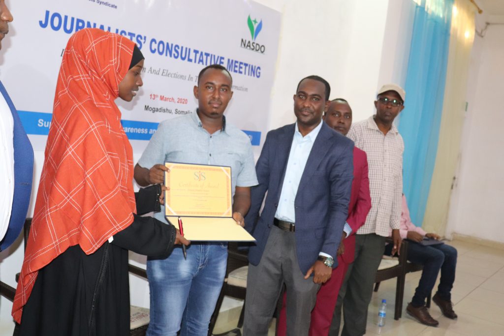 Nafisa Ogle (left) awards journalist Abdiqani Abdullahi of Radio Kulmiye (centre) on Friday, 13 March, 2020.