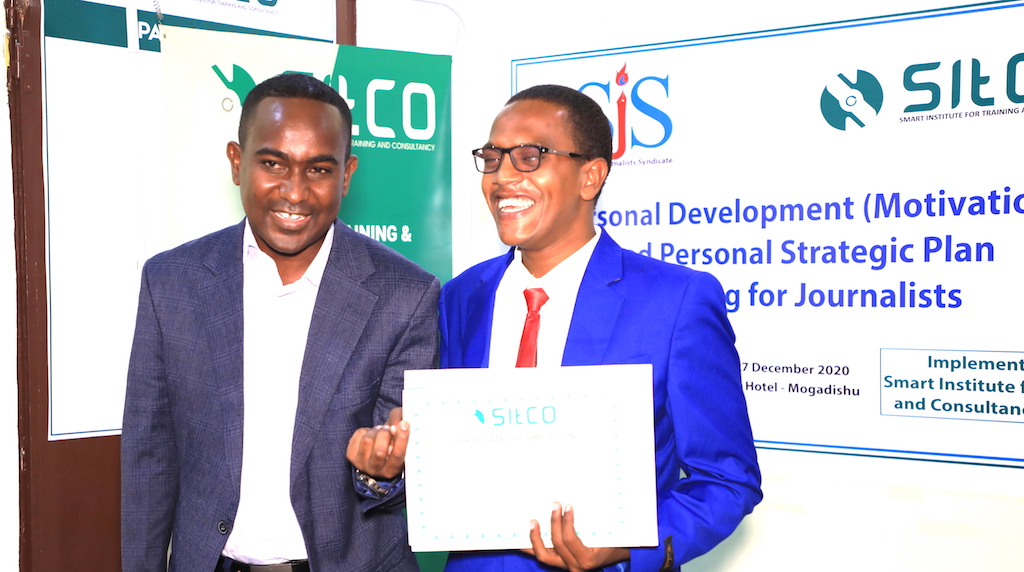 Ismail Abdukadir (right) who is an aspiring blind journalist with Goobjoog Media receives his certificate at the end of three-day training on strategic planning in Mogadishu, Saturday 26 Dec, 2020. |  PHOTO/SJS.