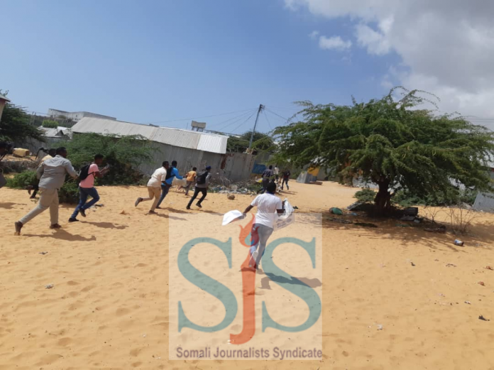 Somali journalists run for shelter after armed police dispersed protestors in Mogadishu on 17 December, 2020.