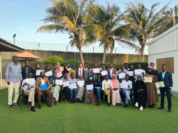 Journalists pose for a group photo alongside British Ambassador, Kate Foster; SJS Secretary-General, Abdalle Mumin and Banadir Police Deputy Commander, Col. Said Baryare on Tuesday 24 May, 2022.