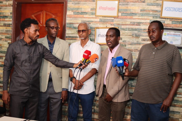 SJS Secretary-General, Abdalle Mumin and FESOJ Secretary-General, Farah Omar (centre) speak on behalf of SMSJ during a press conference in Mogadishu.