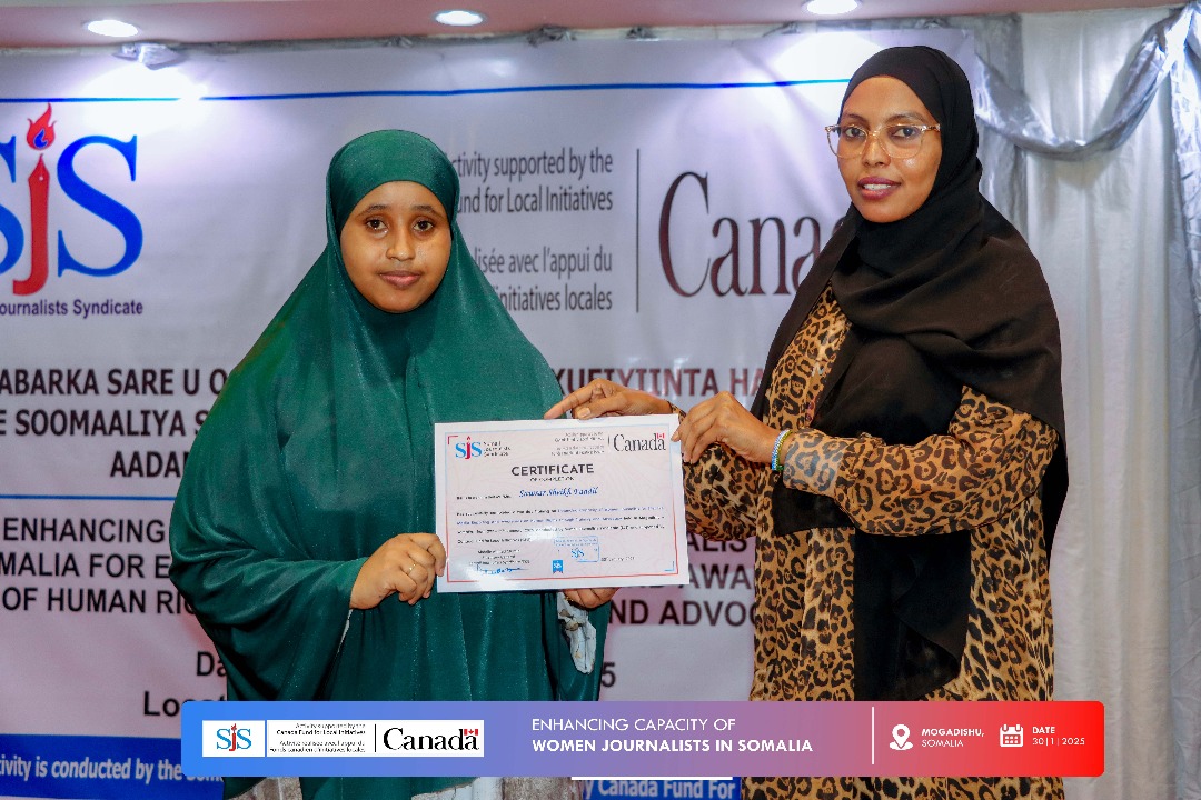 Sawsar Sheikh Faadil (left) receuves her certificate from SJS trainer Halima Abdullahi (right) during the end of a two-day journalists training in Mogadishu, on 30 January, 2025. | PHOTO/SJS.