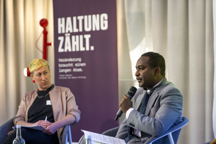 SJS Secretary General, Abdalle Mumin (right) speaks during a panel discussion as part of the the 2025 Symposium organized by Medico International Foundation in Frankfurt, Germany. | PHOTO/ Medico International team.