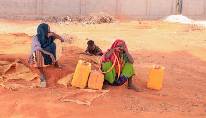 Here in Barkadda Shariifadda village, about 13 km west of Kismayo, Jubaland, on 16 March 2026, women wait for the arrival of a water trucking vehicle brought by an NGO from Kismayo. This is the only water the community can access to survive. | PHOTO/ABDULLAAHI HUSSEIN KILAS/ KAAB TV.